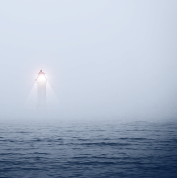 Lighthouse in foggy sea